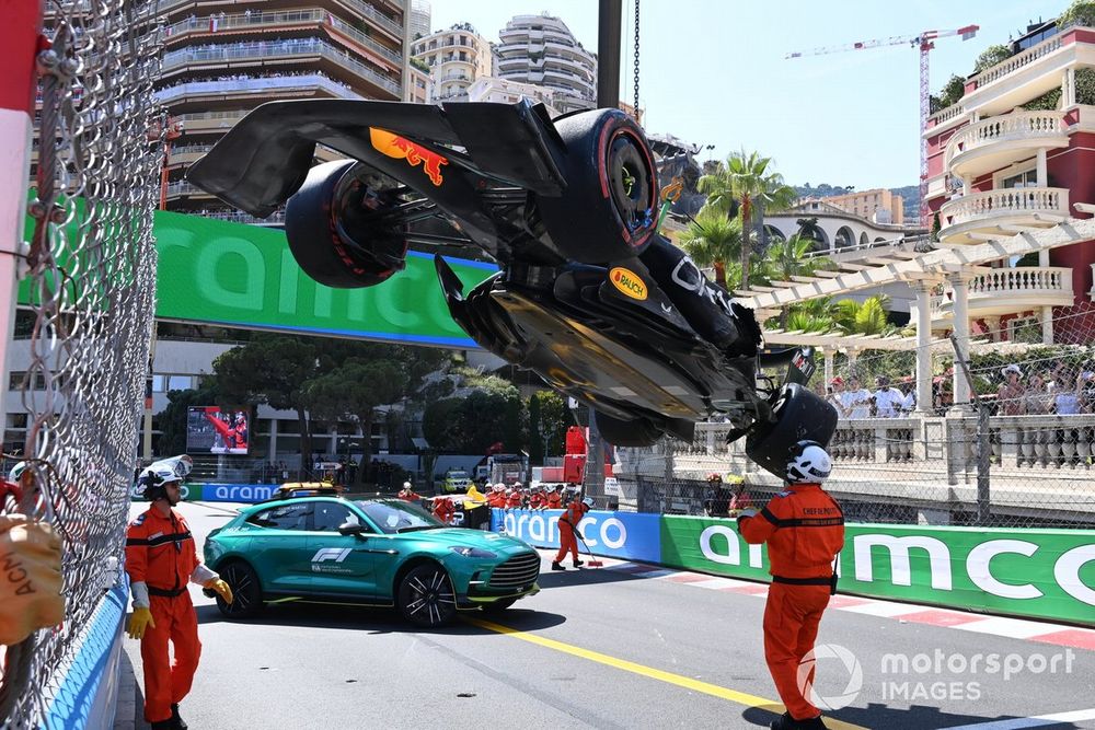 Marshals remove the damaged car of Sergio Perez, Red Bull Racing RB19, from the circuit after a crash in Q1