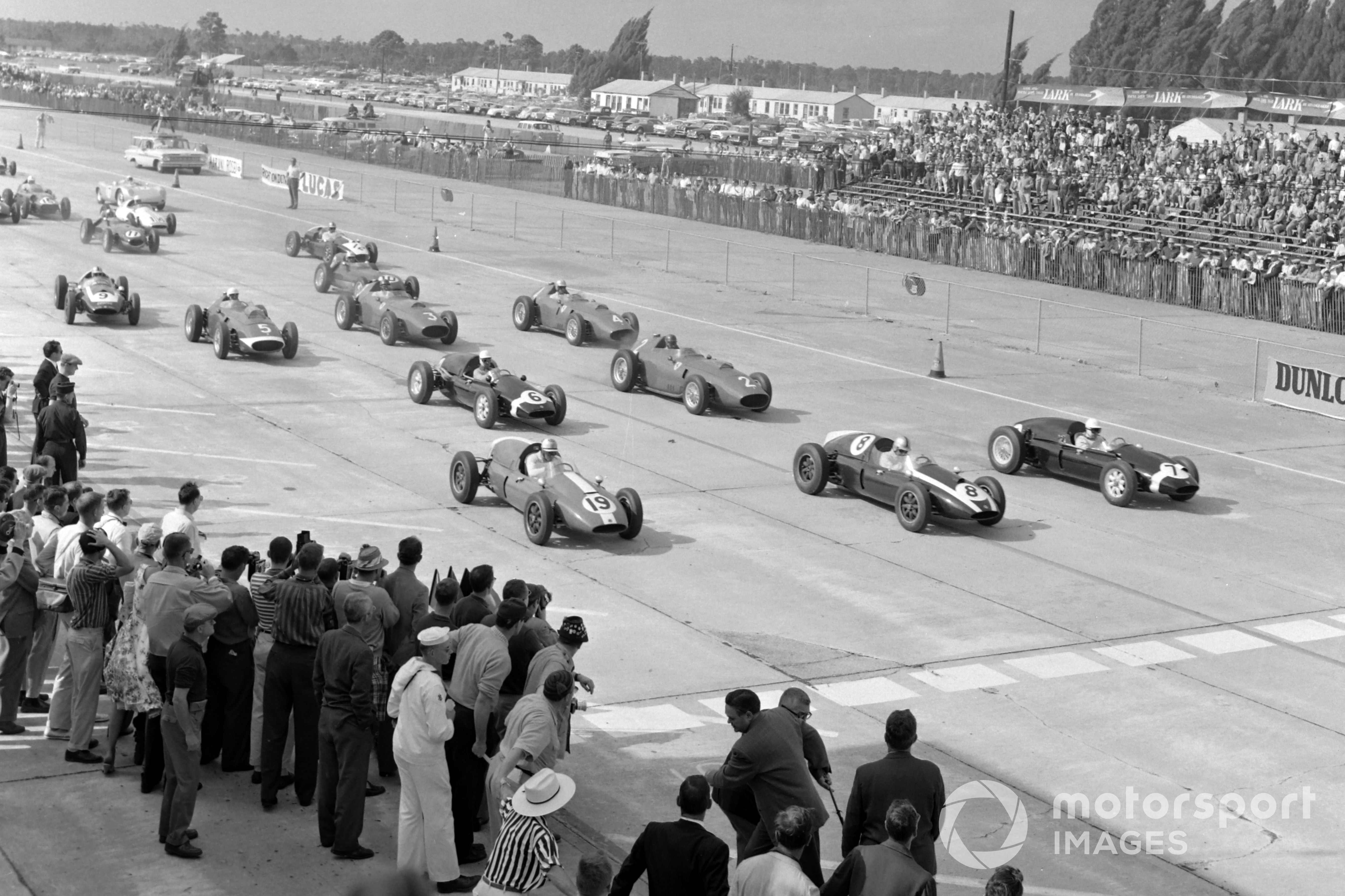 Stirling Moss, Cooper T51 Climax, Jack Brabham, Cooper T51 Climax, and Harry Schell, Cooper T51 Climax, lead the field away at the start.