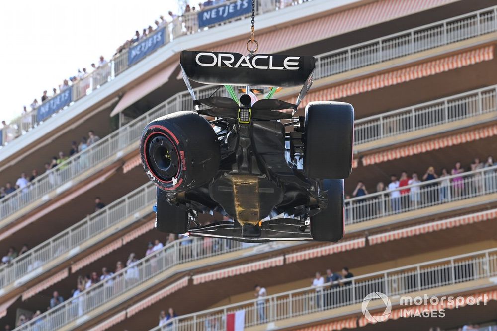 Marshals remove the damaged car of Sergio Perez, Red Bull Racing RB19, from the circuit after a crash in Q1