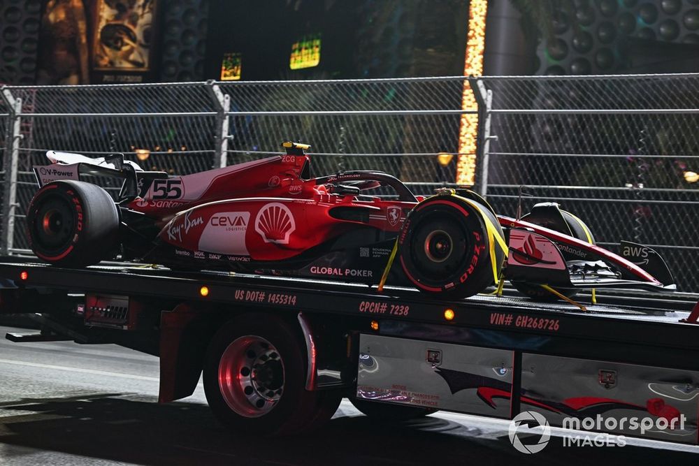 The car of Carlos Sainz, Ferrari SF-23, is returned to the pits on a truck after damage from a loose manhole cover
