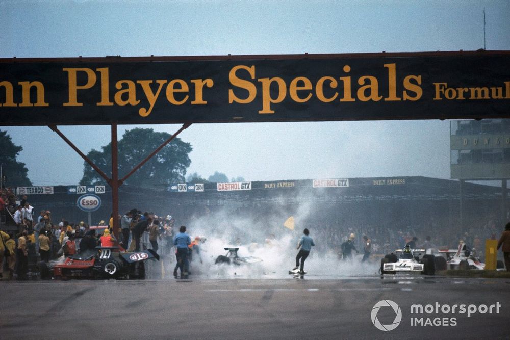 Clearing work after the first lap and the mass crash following the start. Roger Williamson's March 731 Ford sits to the left while Wilson Fittipaldi's Brabham BT42 Ford limps away and Graham Hill pulls across to a halt in his Shadow SN1 Ford