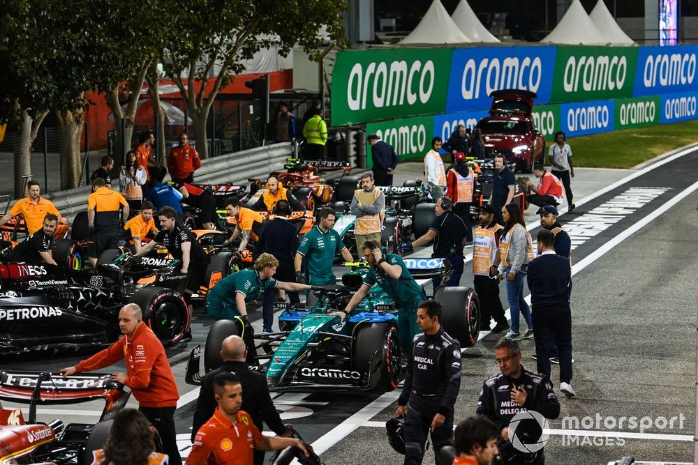 Mechanics collect their cars from Parc Ferme after Qualifying